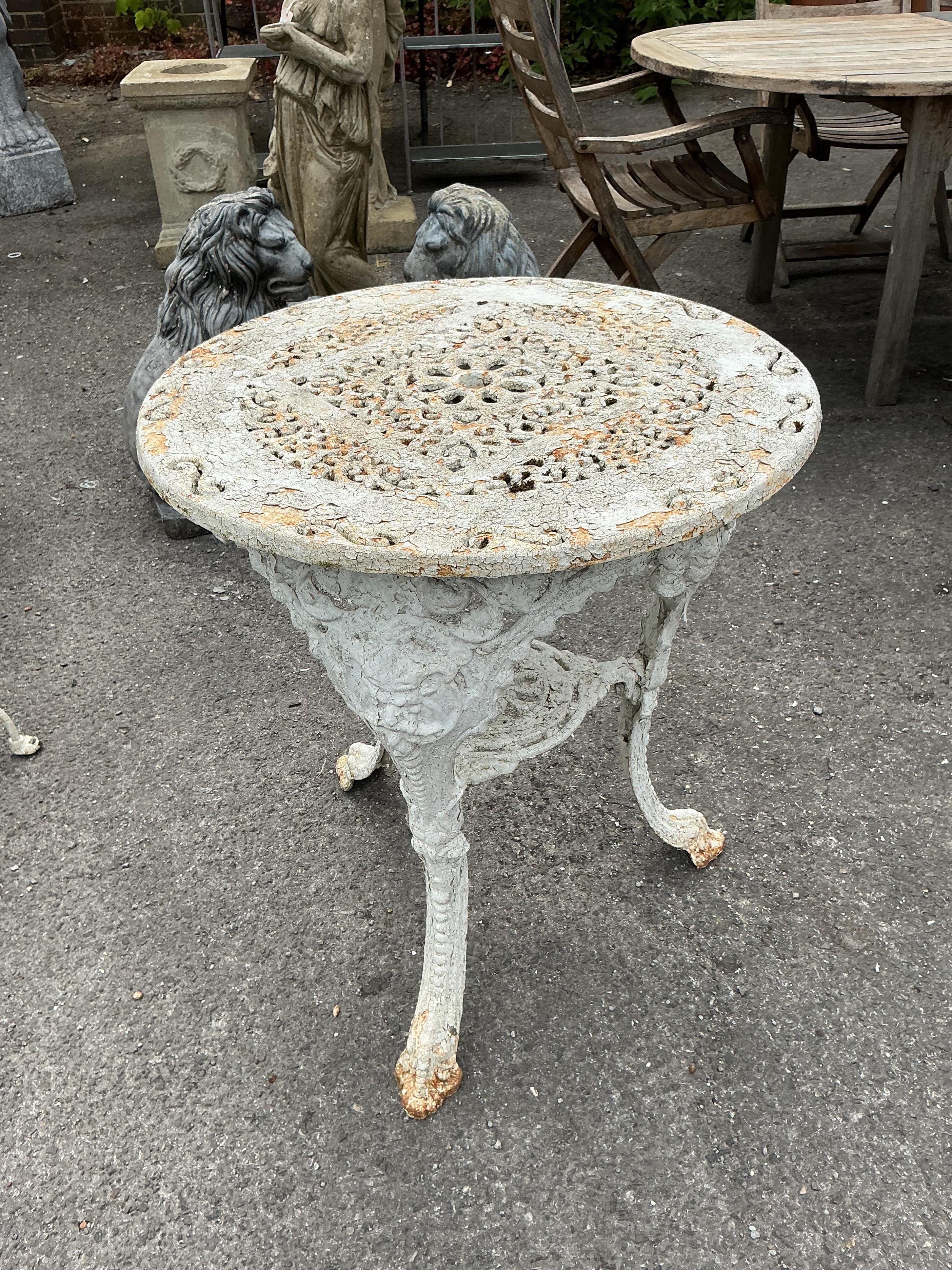 A Victorian Coalbrookdale style later painted circular cast iron garden table, diameter 61cm, height 70cm together with two later chairs